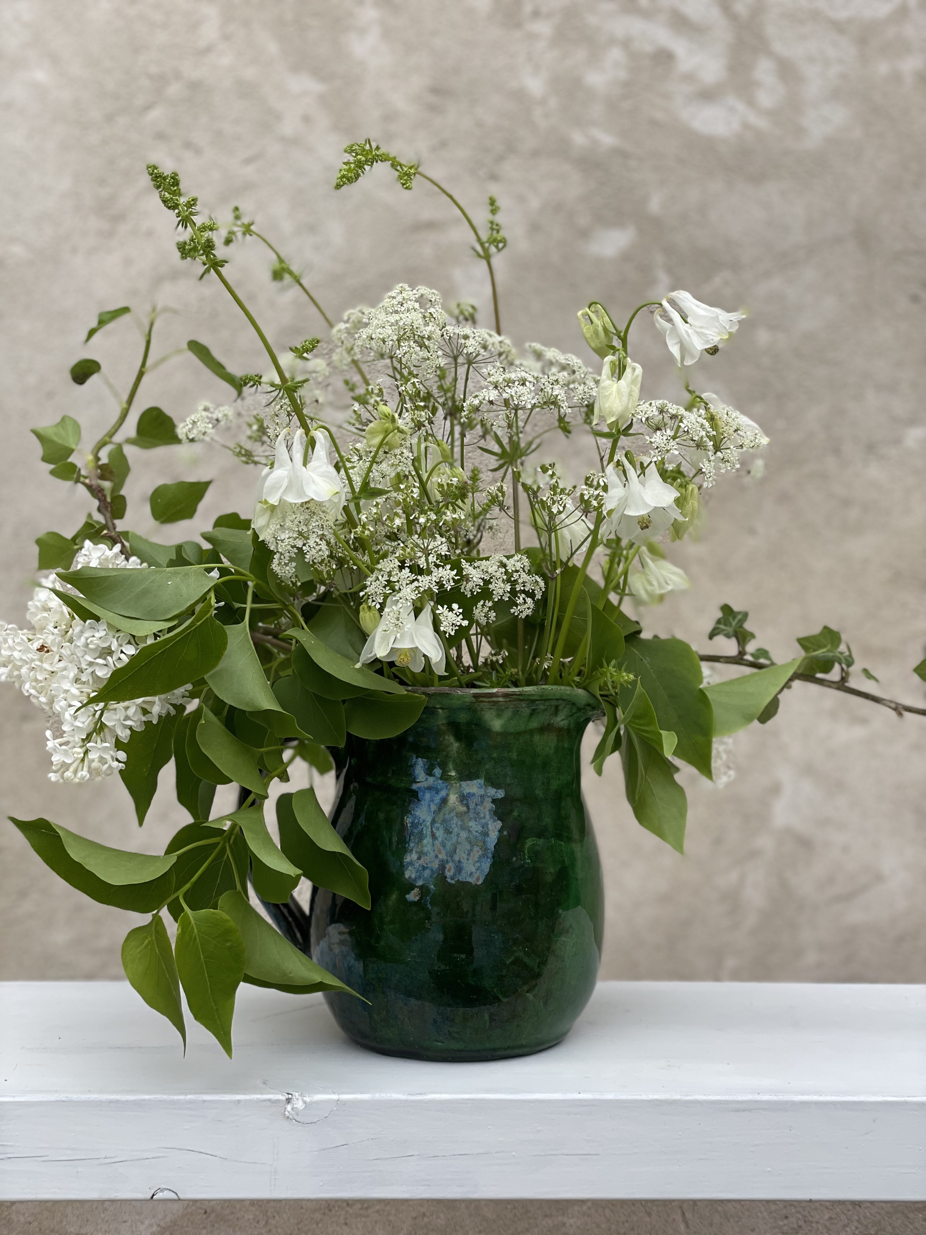 Ängsblommor i en grön kruka, ateljén